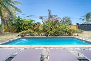 a swimming pool in a yard with two chairs at Villa Aquarium in Saint-François
