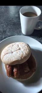 a sandwich on a plate with a cup of coffee at Downhill Beach Studio Suite in Coleraine