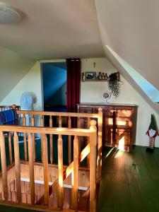 an attic room with a wooden staircase and a stair railing at Dębowy Zakątek in Dębowo