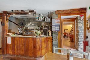a bar in a restaurant with a stone wall at Locanda delle Miniere in Ollomont