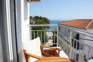 a balcony with a chair and a view of the ocean at Mahi Studios in Patitiri