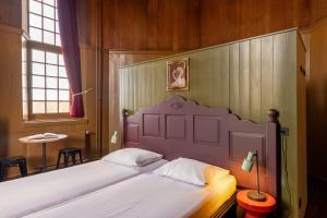 a bedroom with a large bed with a large headboard at Stayokay Hostel Heemskerk - fully renovated April 2026 in Heemskerk +46 photos