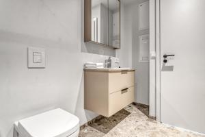 a white bathroom with a toilet and a sink at Amtmann Residence by Heimaleiga in Selfoss +217 photos
