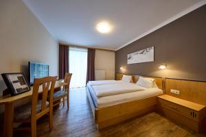 a hotel room with a bed and a desk at Hotel Bärenbachhof in Saalbach-Hinterglemm +58 photos