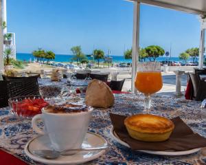 a table with a cup of coffee and a drink at Hotel Alba Chiara Sant'Andrea Salento in SantʼAndrea