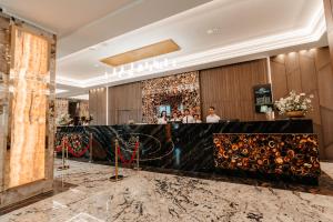 a lobby of a hotel with a black marble counter at Grand Hotel President in Baile Felix +103 photos