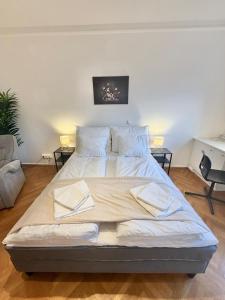 a large bed in a room with two tables at Stilvolles Apartment im Herzen von Krems in Krems an der Donau