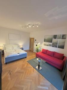 a bedroom with a bed and a red couch at Stilvolles Apartment im Herzen von Krems in Krems an der Donau +11 photos