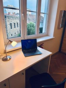 a laptop computer sitting on a desk next to a window at Stilvolles Apartment im Herzen von Krems in Krems an der Donau