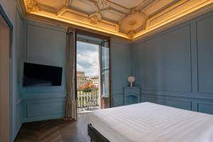 a bedroom with a bed and a large window at Il Rivalta - Place of Charme in Florence