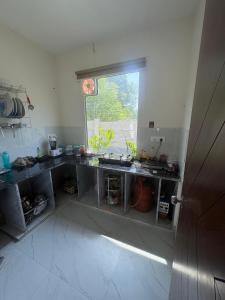 a kitchen with a sink and a window at La Vida Estate Farm in Garhmuktesar