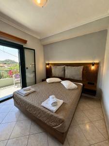 a bedroom with a large bed with towels on it at Hotel Filoxenia in Ligia