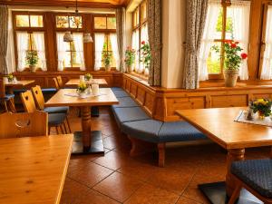 a restaurant with wooden tables and chairs and windows at Hotel Schatten in Garmisch-Partenkirchen