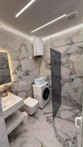 a bathroom with a toilet and a sink and a microwave at Casa Palma Villa in Velipojë +86 photos