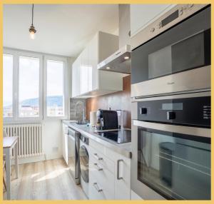 a kitchen with stainless steel appliances and a large window at Chez Gilles I Studio I Ambilly in Ambilly
