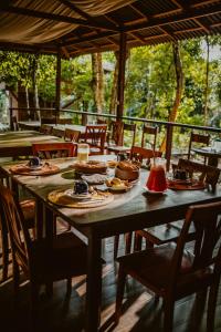 a wooden table with plates of food on it at Villa Arapiuns - 6 Bangalôs na Floresta in Santarém