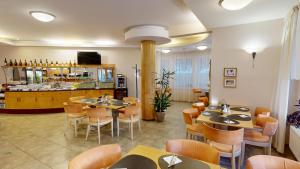 a restaurant with tables and chairs and a counter at Hotel SET in Bratislava