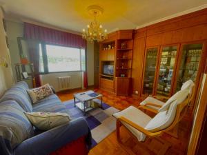 a living room with a blue couch and chairs at El Pescador in Ribadesella