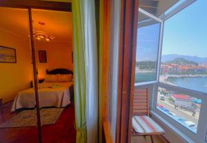 a room with a bed and a large window at El Pescador in Ribadesella