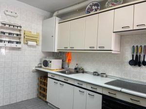 a kitchen with white cabinets and a sink at El Pescador in Ribadesella
