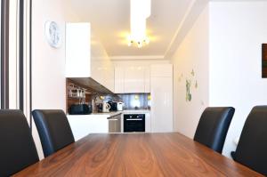 a dining room table with black chairs and a kitchen at Apartment Trnje in Zagreb
