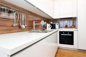 a kitchen with white cabinets and a sink at Apartment Trnje in Zagreb