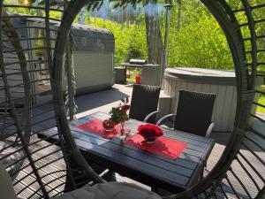 a wooden table with flowers on a patio at Citi Krasti Eco Spa Residence in Kārļzemnieki