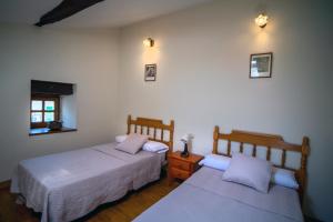 a bedroom with two beds and a nightstand with twoermottermott at La Posada Nueva in Viscarret-Guerendiáin