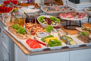 a buffet with many different types of food on a table at Hotel Boss in Łódź