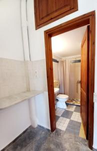 a bathroom with a toilet and a door open at Genos suites in Stavros +126 photos