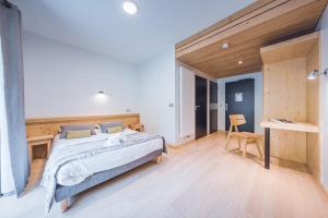 a bedroom with a large bed and a desk at L'Auberge Nordique in Le Grand-Bornand +23 photos