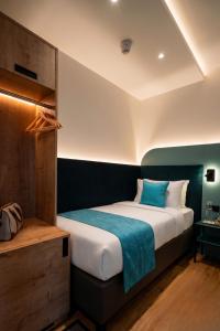 a bedroom with a bed with a blue blanket at H24 Hotel Berlin Grünau in Berlin
