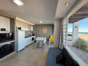 a kitchen and dining room with a view of the ocean at Bahia creek in Las Grutas