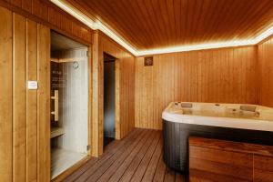 a bathroom with a bath tub in a wooden room at Shellter Apartments by the sea in Vieira de Leiria +51 photos