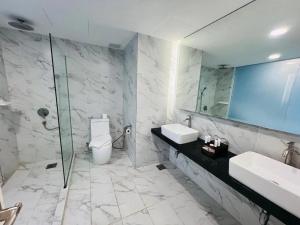a bathroom with two sinks and a shower and a toilet at Grand Flora Hotel in Malacca +16 photos