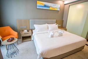 a bedroom with a bed with two stuffed animals on it at Grand Flora Hotel in Malacca