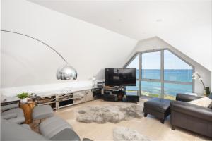 a living room with a couch and a large window at The Penthouse Fistral Beach, Newquay in Crantock