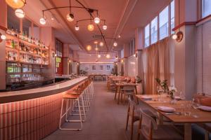 a restaurant with tables and chairs and a bar at Craftsman Bangkok in Bangkok