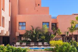a building with a pool in front of a resort at Hotel Xaluca Dades in Boumalne Dades +7 photos