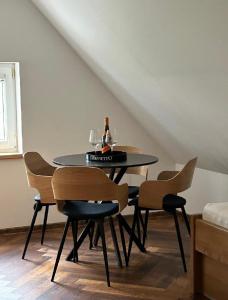 a dining room table with chairs and a bottle of wine at Na Špici Bítov in Bítov