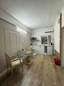 a living room with a glass table and a chair at Home Star 2 in Dāliyat el Karmil
