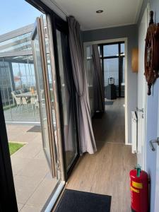 an open door to a balcony with a view of the ocean at Luxus Chalet Visarend 13 Strandkristall in Hulshorst