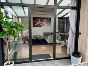 a living room with sliding glass doors at Luxus Chalet Visarend 13 Strandkristall in Hulshorst +12 photos