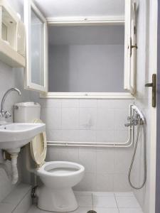 a white bathroom with a toilet and a sink at Galatas home in Galatas +19 photos