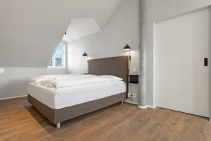 a white bedroom with a bed and a window at Amtmann Residence by Heimaleiga in Selfoss
