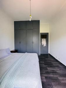 a bedroom with a large white bed and cabinets at Chambre du jardin in Rabat +2 photos