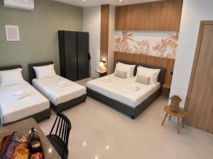 a hotel room with two beds and a table at United Cretan Villas Boutique Studio in Agia Marina Nea Kydonias