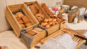 a table topped with wooden boxes filled with different types of bread at Haraldvollen Red Cross Center in Bardufoss