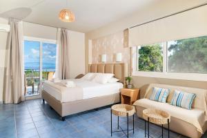 a bedroom with a bed and a couch and a window at Kohylia by La Scala Beach in Limenas +38 photos