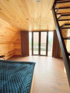 a room with a bed and wooden ceilings and windows at Homestay Gió Mộc !!! in Làng Môn